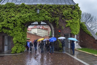 Tourists with umbrellas on Wavel Hill, Krakow, Poland