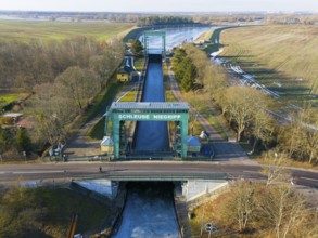 Close-up of Niegripp lock seen over a flat bridge with surrounding forest, aerial view, Niegripp
