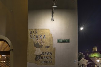 Advertisement for a bar on a house wall, Krakow, Poland