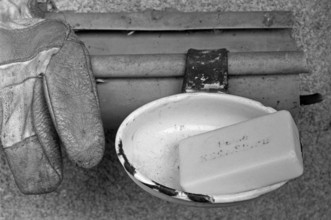 Core soap in a bowl in front of the cowshed on a farm in front of the stable, black and white,