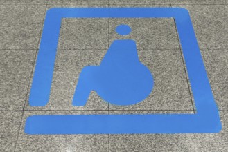 Sign for disabled people in front of a baggage carousel at the airport, Krakow, Poland