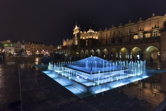 Illuminated fountain with cloth halls at night, Market Square, Krakow, Poland