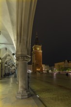 Bell tower and arcade of the Cloth Hall on the Market Square at night, Krakow, Poland