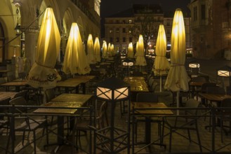 Illuminated umbrellas in a restaurant on the market square at night, Krakow, Poland
