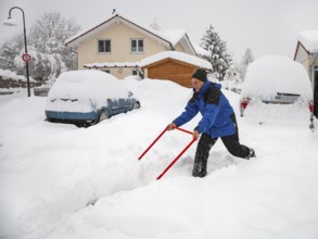 Man clearing snow in front of house, snow chaos, cars, deep snow, Upper Bavaria, Germany
