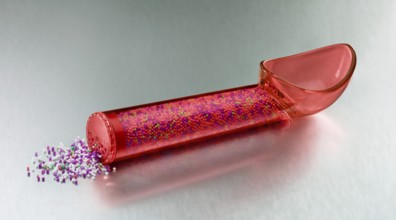 Red, transparent ice cream scoop filled with coloured sugar sprinkles