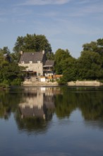 19th century multistory old cut stone home with weathered cedar shingles roof and backyard built on