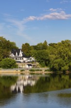 19th century multistory old white clapboard home with black rooftops and backyard built on edge of