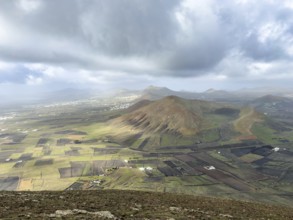 View of Montaña Tesa volcano from Montaña Blanca mountain with cloudy sky, Lanzarote, Canary