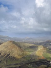 View of Montaña Tesa volcano from Montaña Blanca mountain with cloudy sky, Lanzarote, Canary