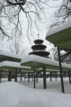 Winter in the English Garden, snow-covered beer garden tables and benches, Chinese Tower, Munich,
