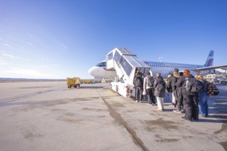Passengers board a Eurowings aircraft under clear skies, Stuttgart Airport, Germany