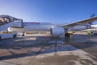 Eurowings aircraft on the ground with mobile stairs and clear blue sky in the background, Stuttgart