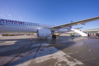 A Eurowings plane at an airport with people boarding a flight of stairs, Stuttgart Airport, Germany