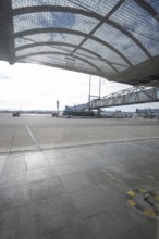 View of the apron of an airport with a bus and a mesh roof in bright sunlight, Stuttgart Airport,