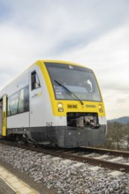 A train travels head-on on rails through rural areas under a cloudy sky, taking off the Hermann