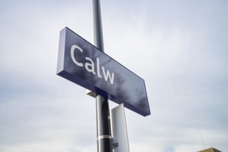 A simple sign with 'Calw' in blue against a cloudy sky, Abfahrt der Hermann Hessebahn, Calw,