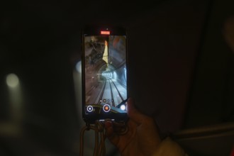 Smartphone shows video recording of an illuminated tunnel in a dark environment, the Hermann