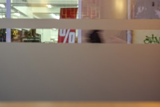 Symbolic picture of final sale: A percentage sign visible through the shop windows of a retail