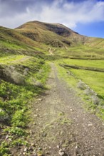 Green trail in a hilly valley under blue skies, Yaiza Lanzarote