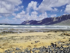 Wide beach with rocky coast and mountains in the background, Caleta de Famara Lanzarote