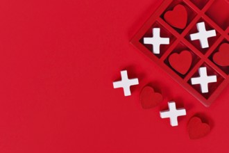 Valentine-themed heart game with red hearts and white Xs in a red box on a red background with copy