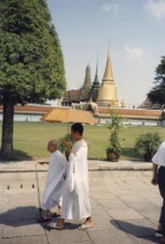 Bhikkhuni, Buddhist nuns walking with parasol in front of Wat Phra Kaeo, (Temple of the Emerald