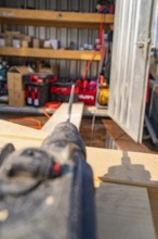 Close-up of a drill in a workshop environment with shelves and order, carpentry, new building,