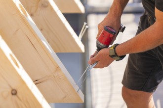 Close-up of a worker screwing a board with a drill, carpentry, new building, Stuttgart, Germany