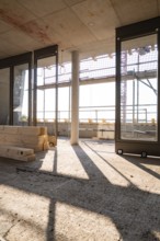 Interior view of a shell with large windows and incoming sunlight, carpentry, new building,