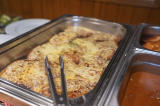 A meat dish with melted cheese in a metal mold