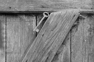 Key on a stable door on a former Franconian farm, black and white, Bavaria, Germany