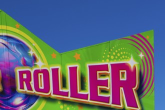 Close-up of the word Roller painted in purple fluorescent paint on banner at Fun Show traveling