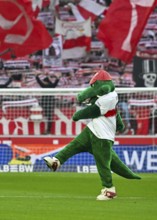 Mascot Fritzle VfB Stuttgart kicks in front of fan block, fans, fan curve, flags, atmosphere,