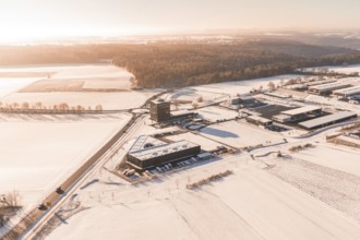 Snowy field, industrial area on the horizon under morning light, Nagold, Calw district, Black