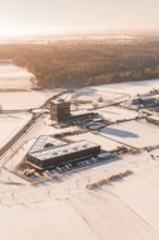 Snow-covered industrial area surrounded by extensive fields in wintry weather, Nagold, Calw