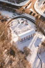 Construction work on a snowy area next to a road and a building, Nagold, Calw district, Black