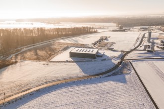 Snow-covered industrial plants and fields under clear sky at sunrise, Nagold, Calw district, Black