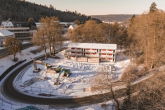 Snowy building site with surrounding trees and hilly winter landscape, Nagold, Calw district, Black