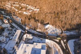 Aerial view of a snowy village surrounded by forest and roads in a wintry atmosphere, Nagold, Calw