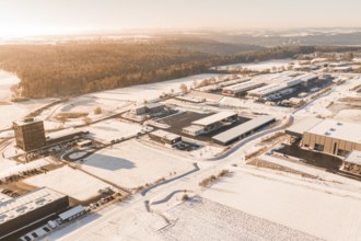 Large production building in snowy landscape with adjacent forest, Nagold, Calw district, Black