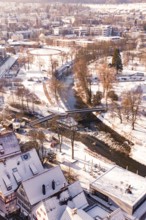 Wintery cityscape with river and bridge, houses and roads covered by snow, Nagold, Calw district,