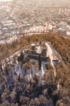 Snowy castle surrounded by trees and city, bird's-eye view of winter atmosphere, Nagold, Calw