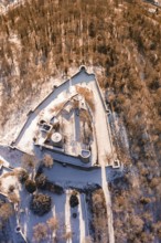 Aerial view of a snowy castle with a triangular layout surrounded by trees, Nagold, Calw district,