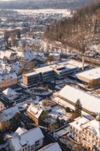 Bird's eye view of school buildings and houses in snowy winter landscape with hills, Nagold, Calw