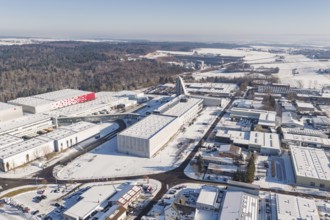 Aerial view of a snowy industrial area with factory buildings and adjacent forest, Nagold, Calw
