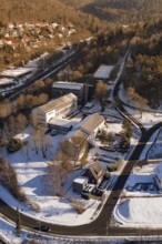 Aerial view of snowy cityscape with buildings, trees and surrounding hills, Nagold, Calw district,