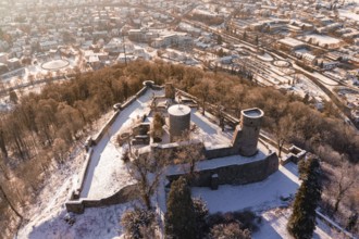 Snowy castle from a bird's eye view, surrounded by city and forest landscape, Nagold, Calw
