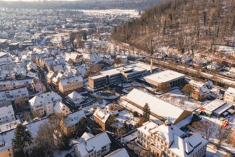 Aerial view of a snowy town surrounded by forest landscape and hills, Nagold, Calw district, Black