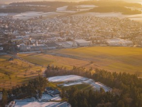 Panorama of city and landscape in evening light, with fields and forests in a winter setting,